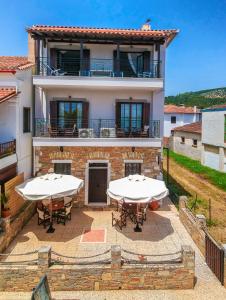 a house with two tables in front of it at Harmony Seaside Pelion in Platanias