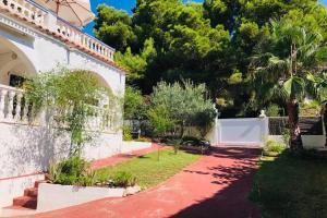 a house with a red walkway next to a yard at Paraíso de playas y luz in Alcossebre