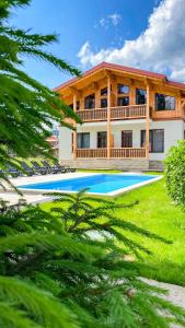 a house with a swimming pool in front of it at Apartments Chalet Girska Hatyna in Vorokhta