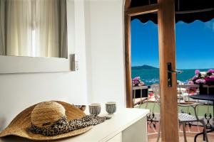 a hat sitting on a counter with a view of the ocean at Liman Hotel Gümüslük - Adult Only in Bodrum City