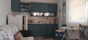 a kitchen with blue cabinets and a refrigerator at Cozy house 3 in Vrachati