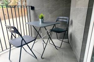 a table and two chairs on a balcony at Modern 1 Bedroom Apartment, Close to the Beach with Parking in Bournemouth
