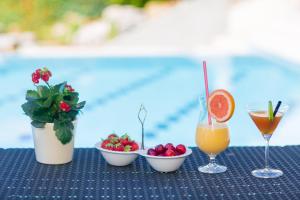 a table topped with bowls of fruit and a drink at Villa Luce Konavoka in Čilipi