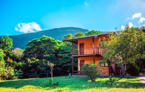 an orange house with a balcony on a hill at Pousada Rosa dos Ventos Capão in Vale do Capao +55 photos