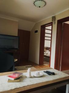 a living room with a table with a tv and a table sidx sidx at Vikendica,Bungalovi Lipska pećina in Cetinje