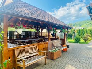 a pavilion with benches and a table and chairs at Pensiunea Galileo in Borşa