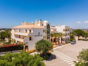 a large white building with a parking lot at Vale d'El Rei Hotel & Villas in Carvoeiro