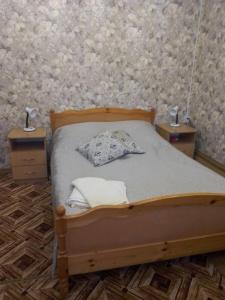 スーズダリにあるCottage on Krasnoarmeiskoyのベッドルーム1室(木製ベッド1台、ナイトスタンド2台付)