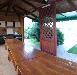 a large wooden table in a kitchen with a large door at Vila Roxy Costinesti in Schitul