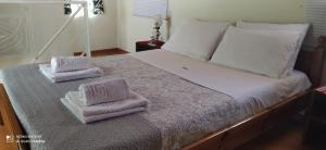 a bed with two towels sitting on top of it at Cozy House in Samoutani in Vrachati