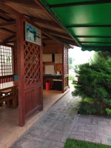 a wooden pavilion with a green roof and a patio at Vila Roxy Costinesti in Schitul