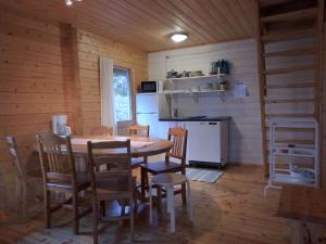 a dining room with a table and chairs and a refrigerator at Solliden Camping in Norrby