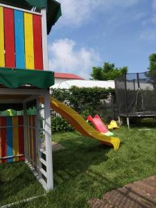 a playground with a slide in the grass at Vila Roxy Costinesti in Schitul