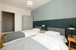 - 2 lits dans une chambre avec un mur vert dans l'établissement LoveSea apartments Rewal, à Rewal