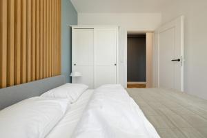 - une chambre avec un grand lit et des draps blancs dans l'établissement LoveSea apartments Rewal, à Rewal