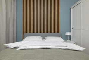 Elle comprend un grand lit blanc avec des draps et des oreillers blancs. dans l'établissement LoveSea apartments Rewal, à Rewal