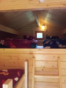 a bedroom with two beds in a log cabin at Männiste Holiday Home in Hiievälja