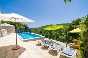 una piscina con sombrillas y sillas y una piscina en House Kočan, en Gruda