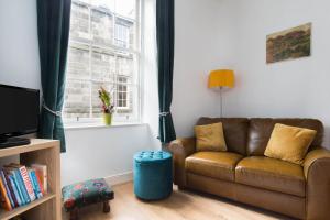 a living room with a couch and a window at Stockbridge Two Bedroom Apartment in Edinburgh