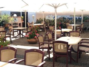 eine Außenterrasse mit Tischen, Stühlen und Blumen in der Unterkunft Hotel Restaurant Germania in Neuwied