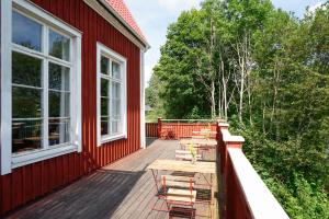 a deck with chairs and tables on a red house at Nordic Refuge B&B in Fröskog