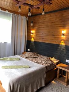 een slaapkamer met een bed met een houten muur bij Guest House Shuan in Chokhuldi