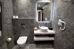 y baño con lavabo, aseo y espejo. en Rose n Stone, Duke, Luxury Houses en Tinos Town