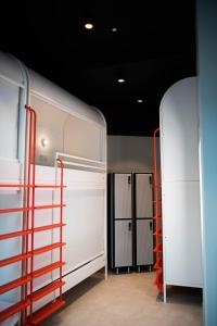 a garage with two white cabinets and red racks at You Hotels Deauville - Handwritten Collection in Deauville