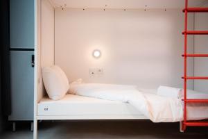 a bed in a room with two shelves at You Hotels Deauville - Handwritten Collection in Deauville