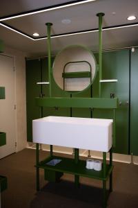 a bathroom with a white sink and a mirror at You Hotels Deauville - Handwritten Collection in Deauville