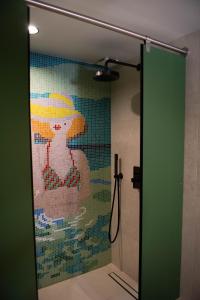 a mosaic of a dog on a shower door in a bathroom at You Hotels Deauville - Handwritten Collection in Deauville