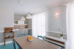 una cucina con un tavolo con una ciotola di arance sopra di Lamare cucina e dimore a Polignano a Mare