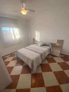 1 dormitorio con 1 cama y suelo a cuadros en Casa Silvia, en Cádiz