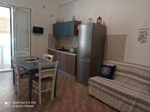 Apartament obejmuje kuchnię oraz salon ze stołem i lodówką. w obiekcie Casa Sferracavallo w mieście Sferracavallo