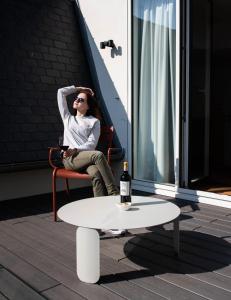 a woman sitting in a chair next to a table with a bottle of wine at YOU Are Deauville in Deauville