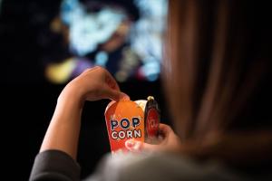 a woman holding a pop corn can in her hands at You Hotels Deauville - Handwritten Collection in Deauville
