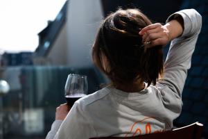 a woman holding a glass of red wine at You Hotels Deauville - Handwritten Collection in Deauville