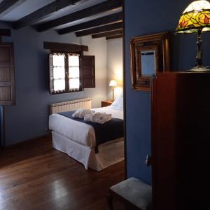 Dormitorio azul con cama y ventana en Posada Reserva Verde en Bárcena Mayor