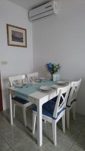 uma mesa de jantar branca com cadeiras e uma toalha de mesa azul em Grand Terrace Sea View Apartment em Lokva Rogoznica