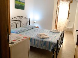 ein Schlafzimmer mit einem Bett und einem Tisch mit Handtüchern darauf in der Unterkunft Affittacamere La saracina in Presicce