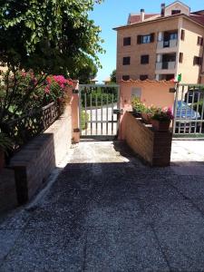 una entrada con una puerta y flores frente a un edificio en "La Gardenia" Affittacamere, en Marina di Montemarciano