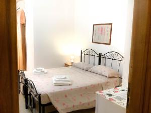 Schlafzimmer mit einem Bett mit schwarzem Rahmen in der Unterkunft Affittacamere La saracina in Presicce