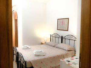 Schlafzimmer mit einem Bett mit schwarzem Rahmen in der Unterkunft Affittacamere La saracina in Presicce