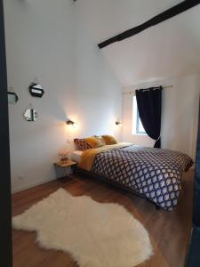 a bedroom with a bed and a rug and a window at Le Loft de blossac in Poitiers