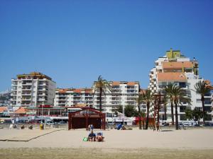 a group of people on a beach with buildings at Peñiscola Playa Orangecosta in Peniscola