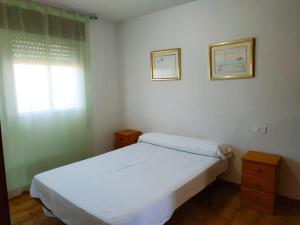 a bedroom with a white bed and a window at Peñiscola Playa Orangecosta in Peniscola