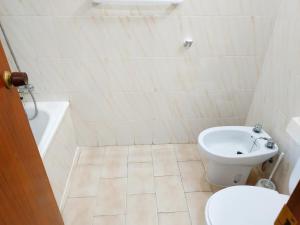 a white bathroom with a toilet and a sink at Peñiscola Playa Orangecosta in Peniscola +7 photos