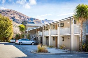 a building with a car parked in a parking lot at Club Wyndham Wanaka, Trademark Collection by Wyndham in Wanaka