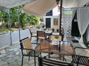 a patio with a table and chairs and an umbrella at ΑΡΓΩ in Kala Nera