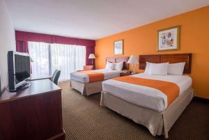 um quarto de hotel com duas camas e uma televisão de ecrã plano em Howard Johnson by Wyndham Fullerton/Anaheim Conference Cntr em Fullerton